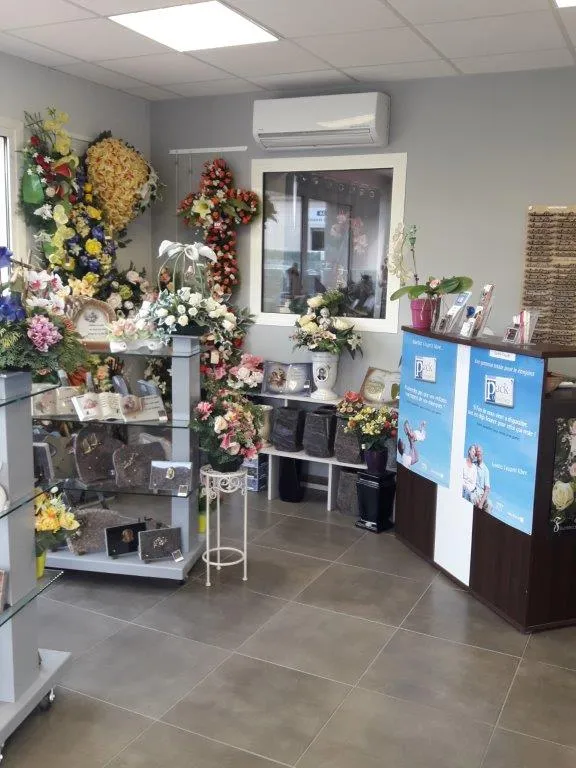 Magasin d'articles funéraires avec comptoir d'accueil, plaques commémoratives et fleurs de deuil