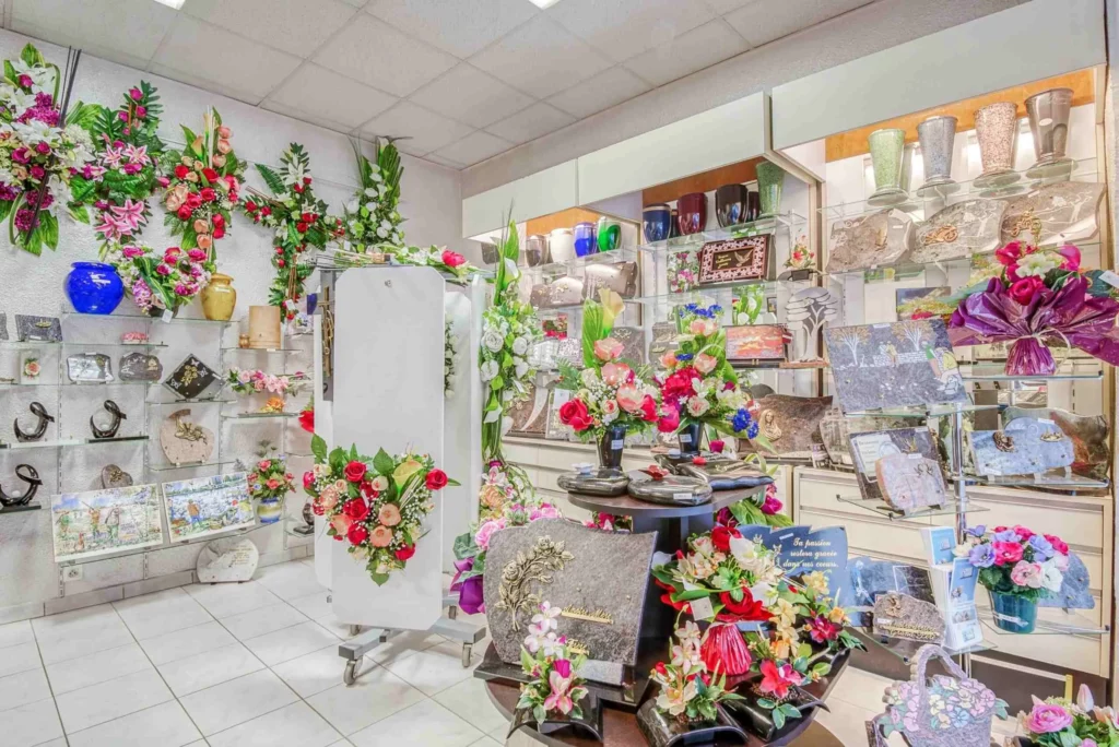 Showroom de pompes funèbres exposant des plaques en granite, urnes et compositions florales